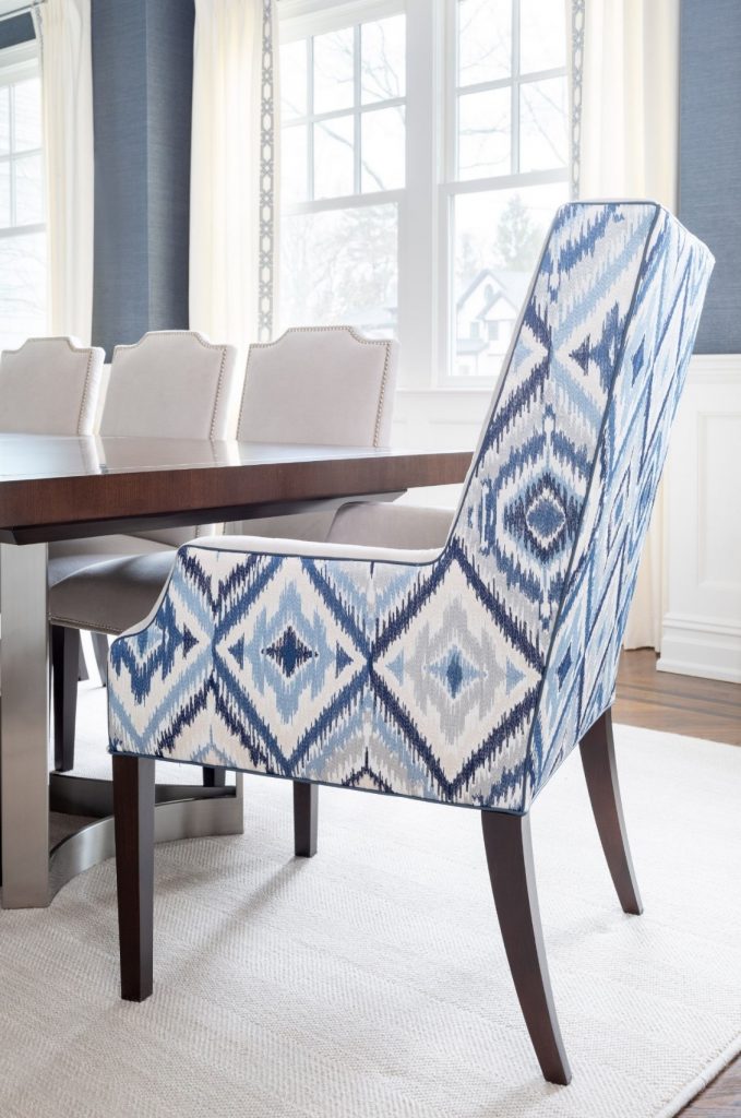 Dining room design, NJ Interior Designer. Bold blue diamond patterned host chair with dark wood legs. 