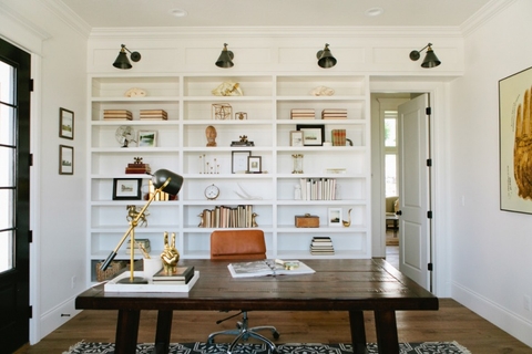 built in white book shelf, dark brown desk, orange chair, desk lamp and decor on shelves. 