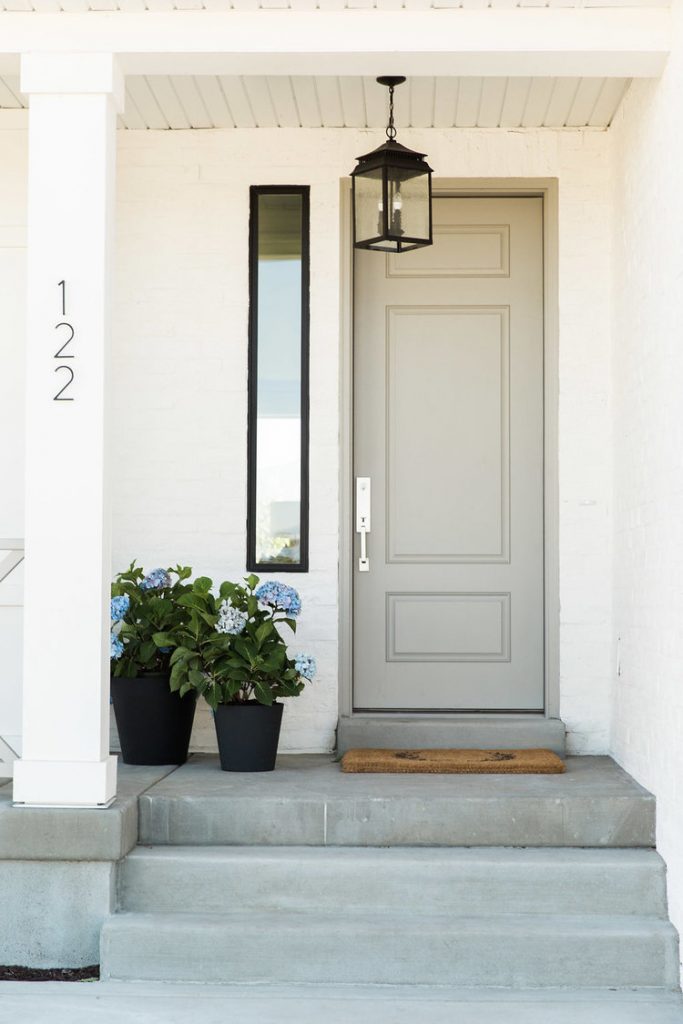 Gray front door with light fixture, sidelite, door mat, and plants. A simple and easy way to boost your curb appeal